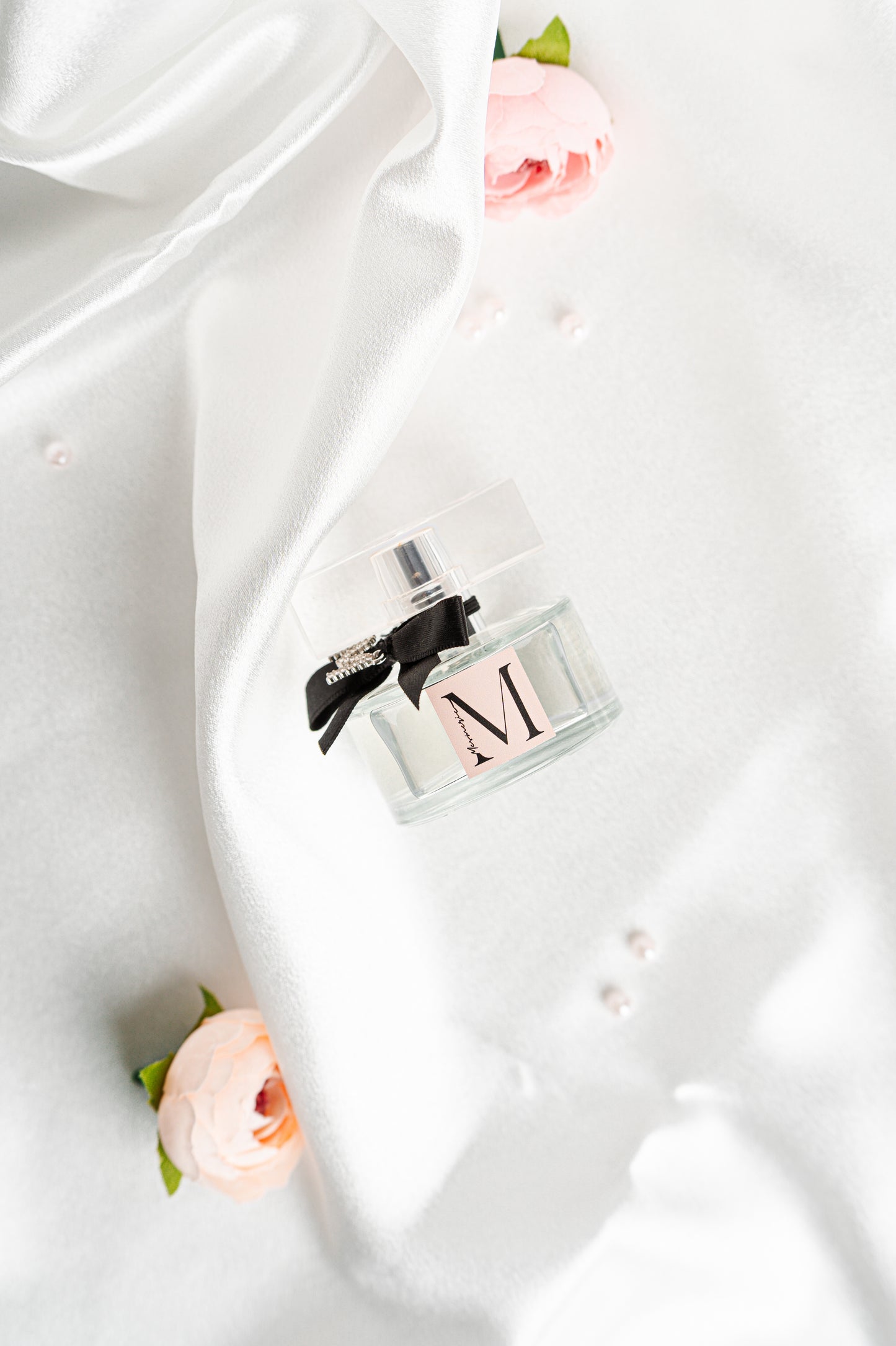 Parfum bottle on white silk satin