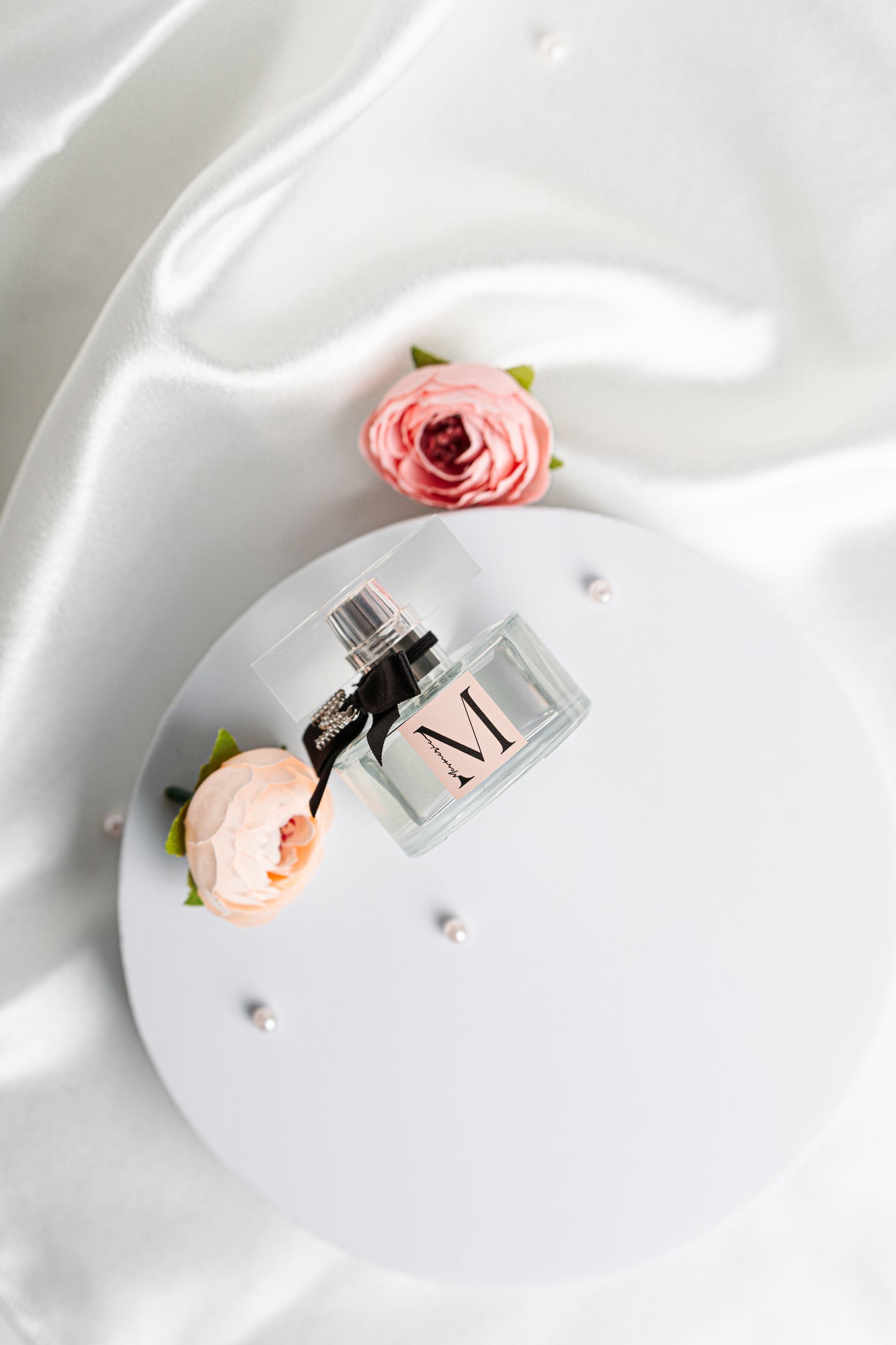 Parfum with pearls and flowers, top view