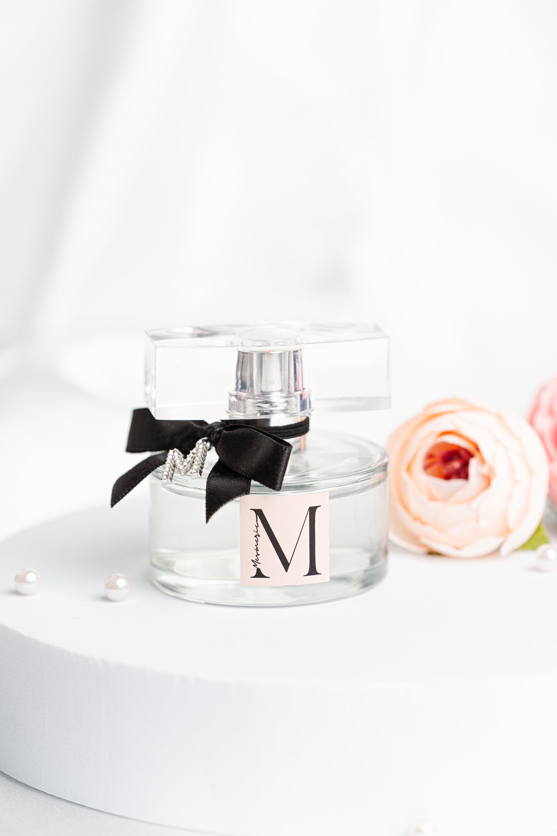Parfum bottle with pink flower, white background