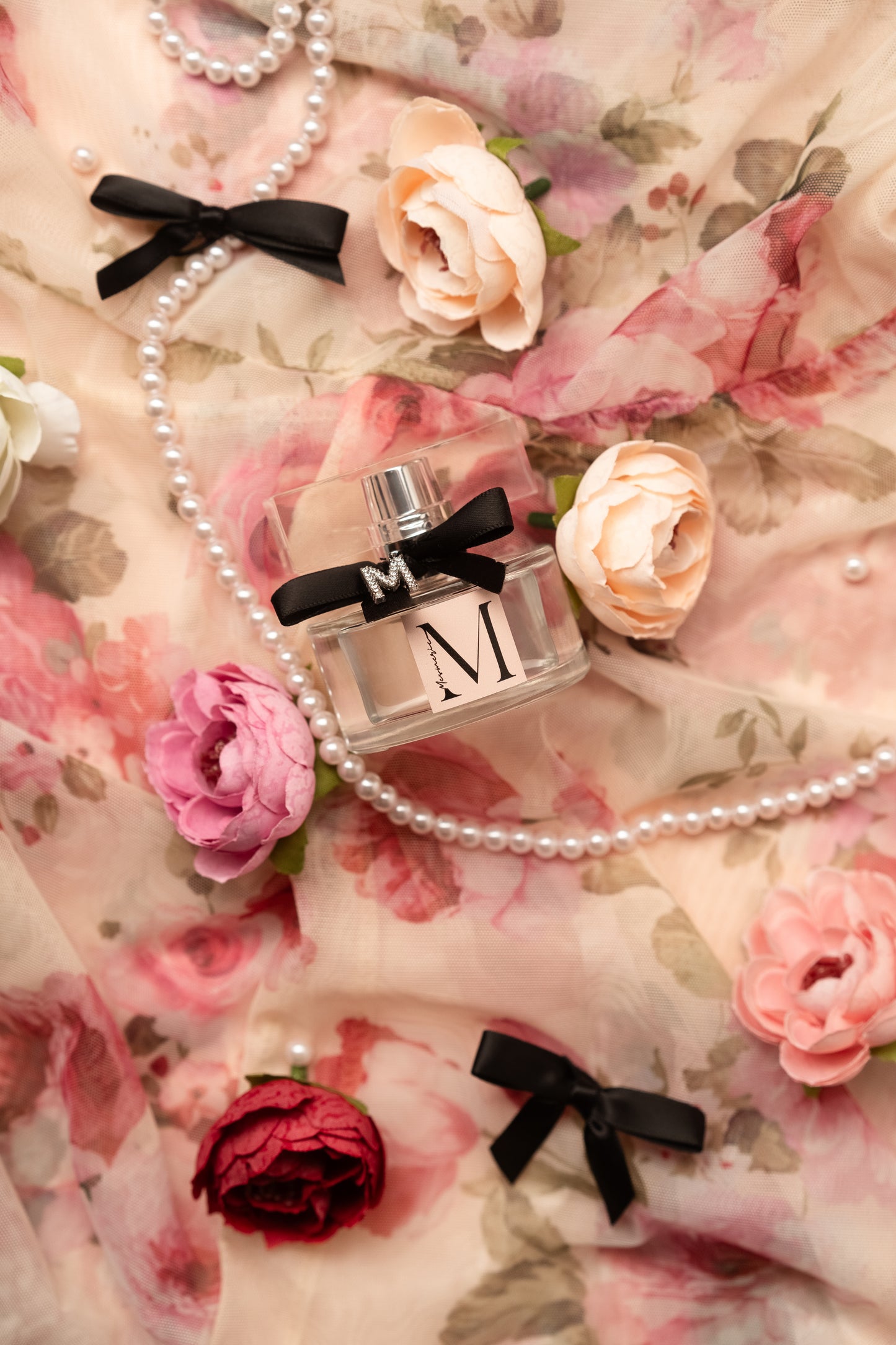 A bottle of parfum next to flowers on flowered background